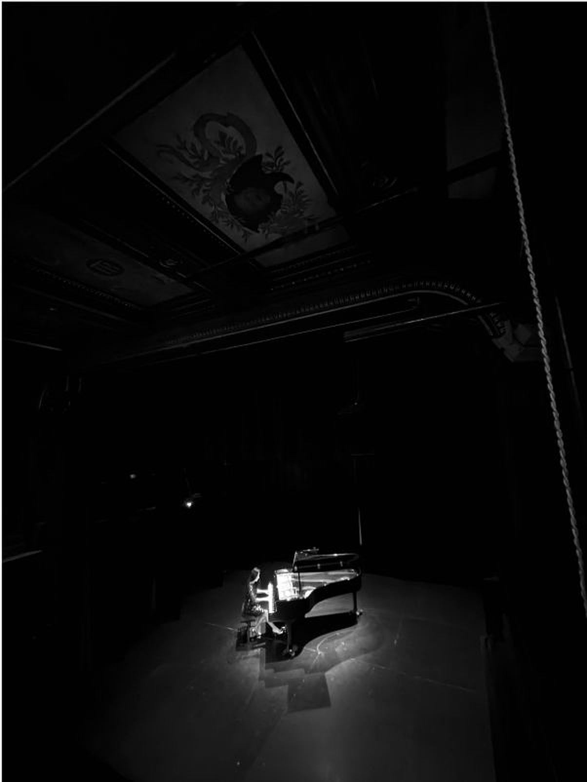 Piano seul, éclairé sur une scène sombre